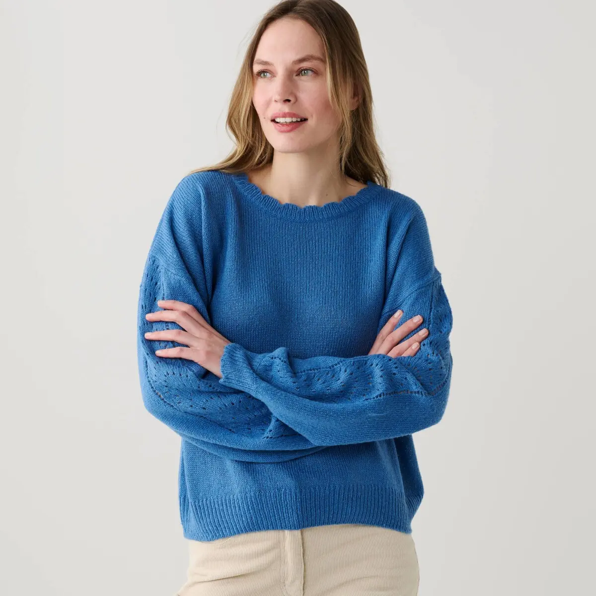Pulovr s ažurovými pruhy na rukávech a vlnkovaným zakončením modrá