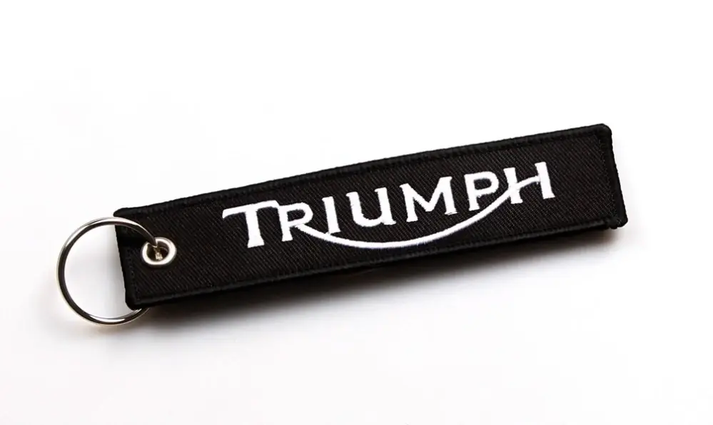 TXR Textilní klíčenka Triumph (Elegantní klíčenka z černého textilního materiálu a s bíle vyšitým nápisem Triumph.)